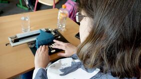 Eine Frau benutzt eine Schreibmaschine für Braille-Schrift.