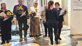 Menschen mit Blumensträuße, eine Frau gratuliert einer anderen Frau. 