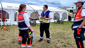 Eine Einsatzkraft spricht mit anderen Einsatzkräften.